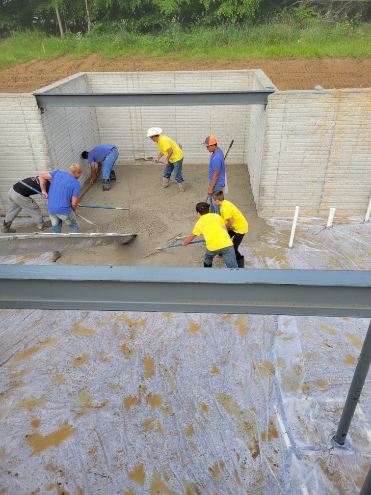 Crew pouring basement floor